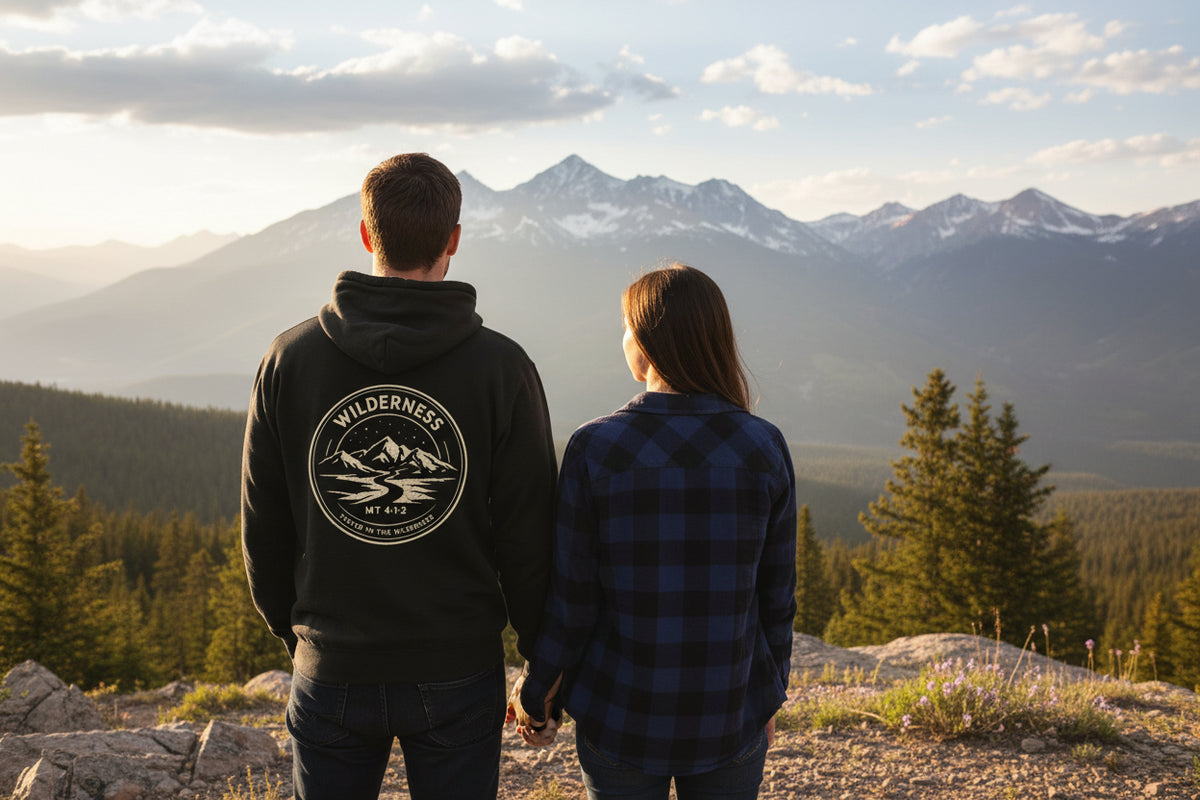 Black hoodie with a wilderness design on the back against a white background