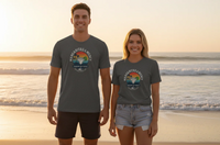 Two people wearing gray t-shirts with a logo on a beach at sunset.