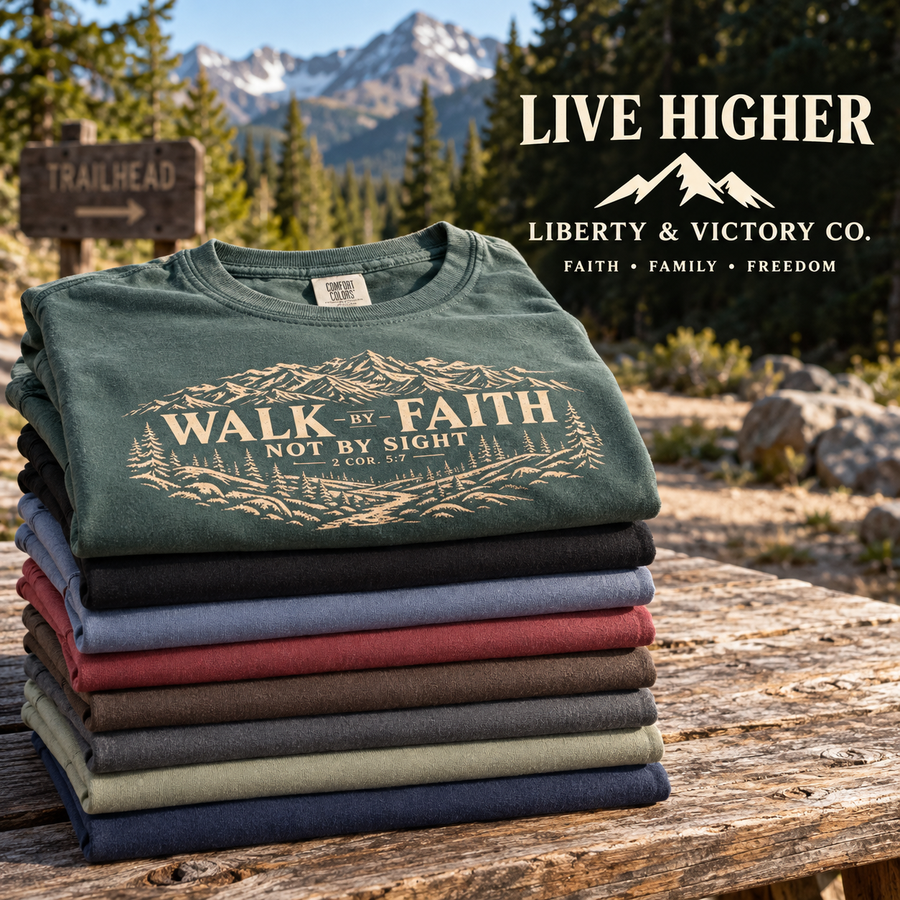 Walk by Faith eight-color shirt stack at a mountain trailhead with Liberty & Victory mountain logo and Live Higher